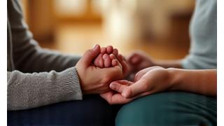 Par zajedno meditira, držeći se za ruke